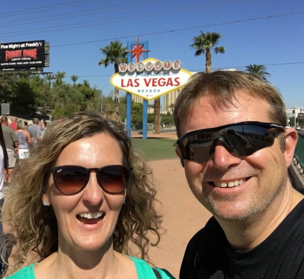 couple  in front of the welcome to las vegas sign one of the cheap things to do in Vegas
