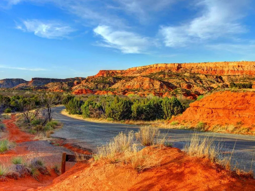 canyon of red dirt and a stream