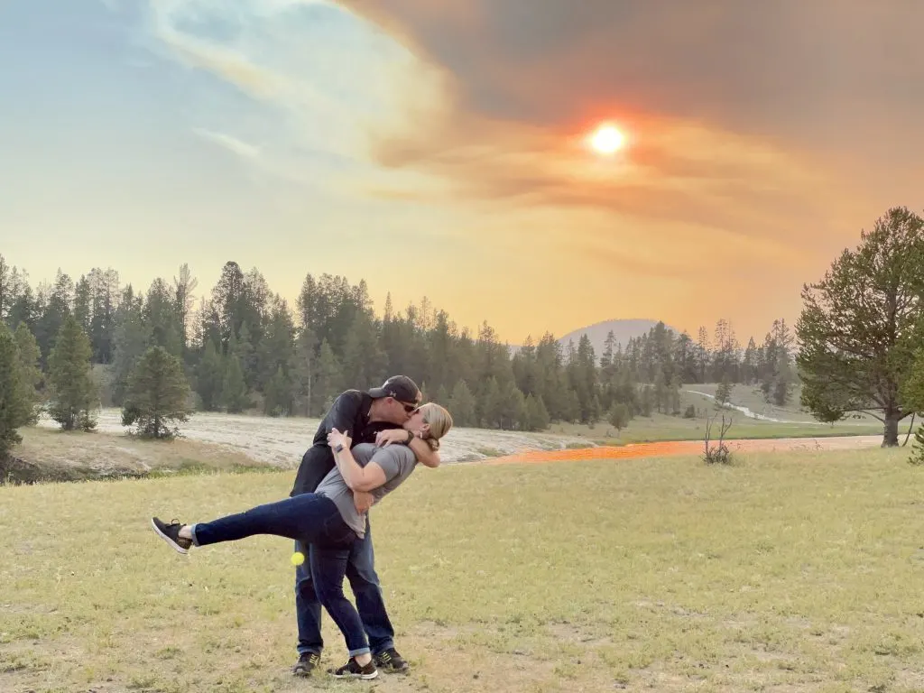 couple dip kissing in sunset of field