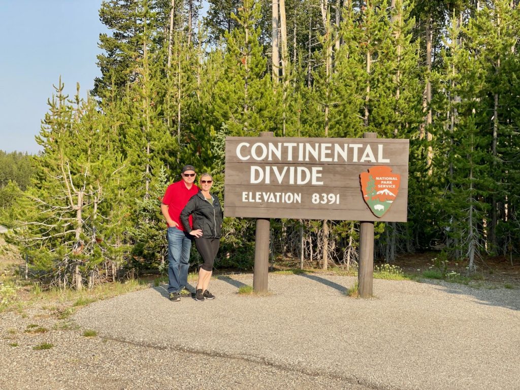 couple standing by Continental divide sign