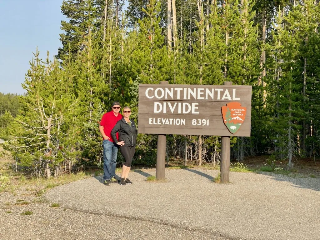 Man and woman standing by the Continental Divide sign in Yellowstone National Park