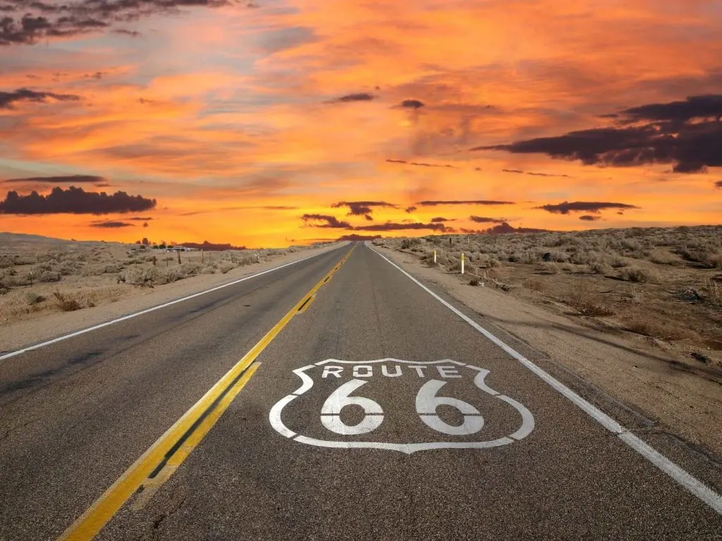 road with route 66 painted on it and sunset in the distance