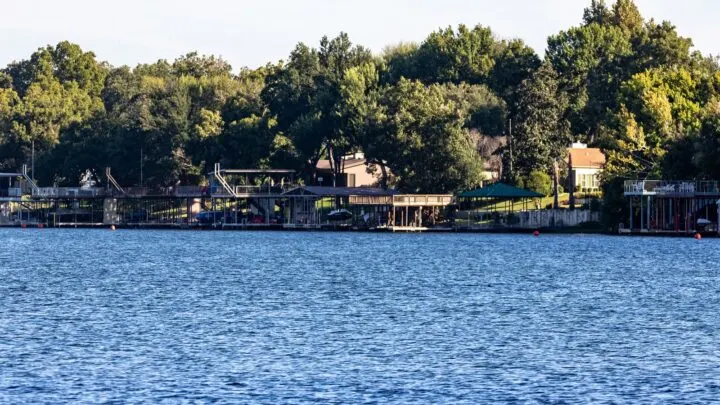 lake with trees and houses in distance