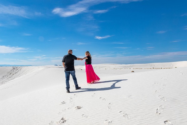 couple dancing surrounded by white sand dunes